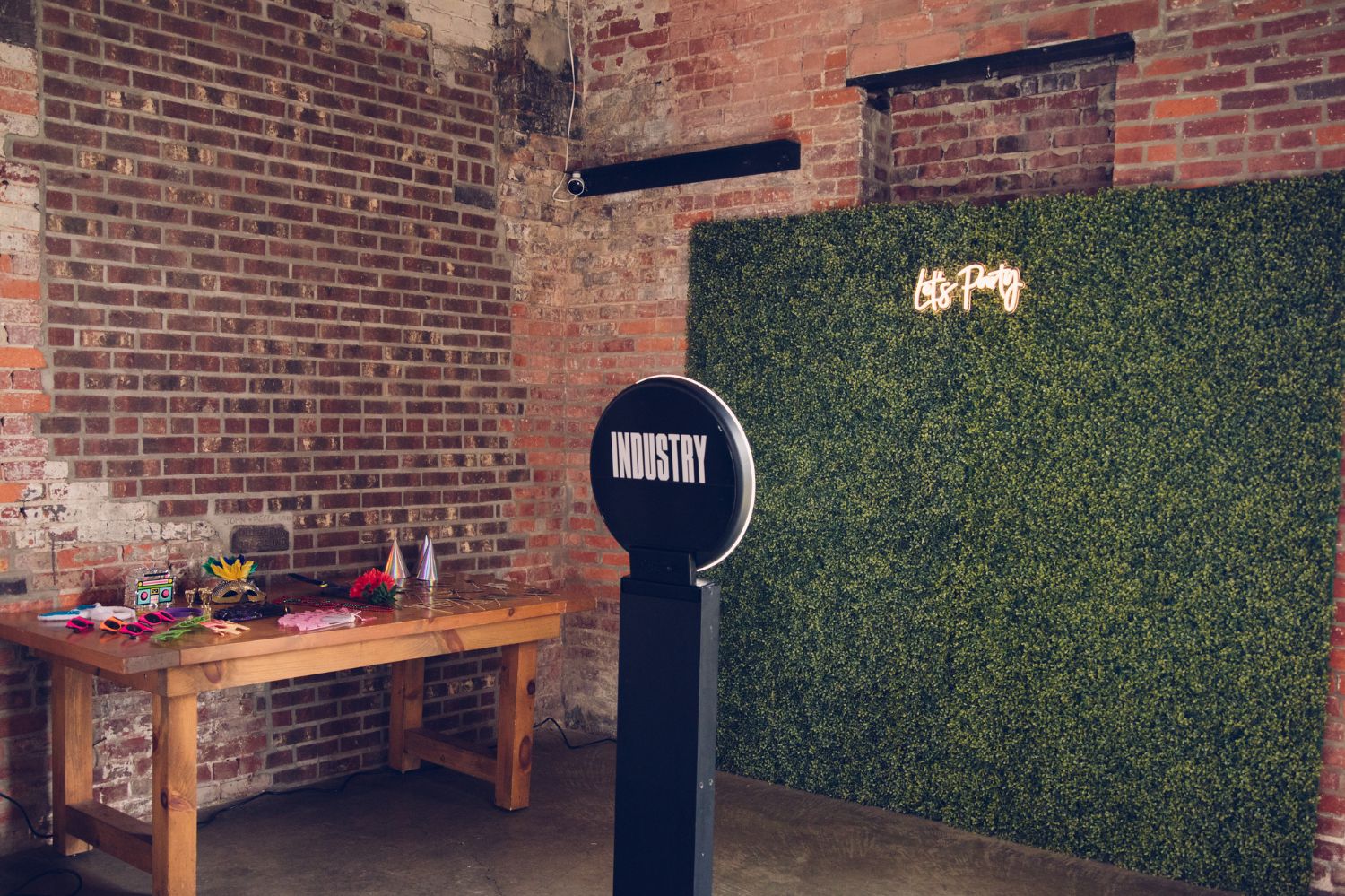 Photo booth area with hedge walls as a backdrop and