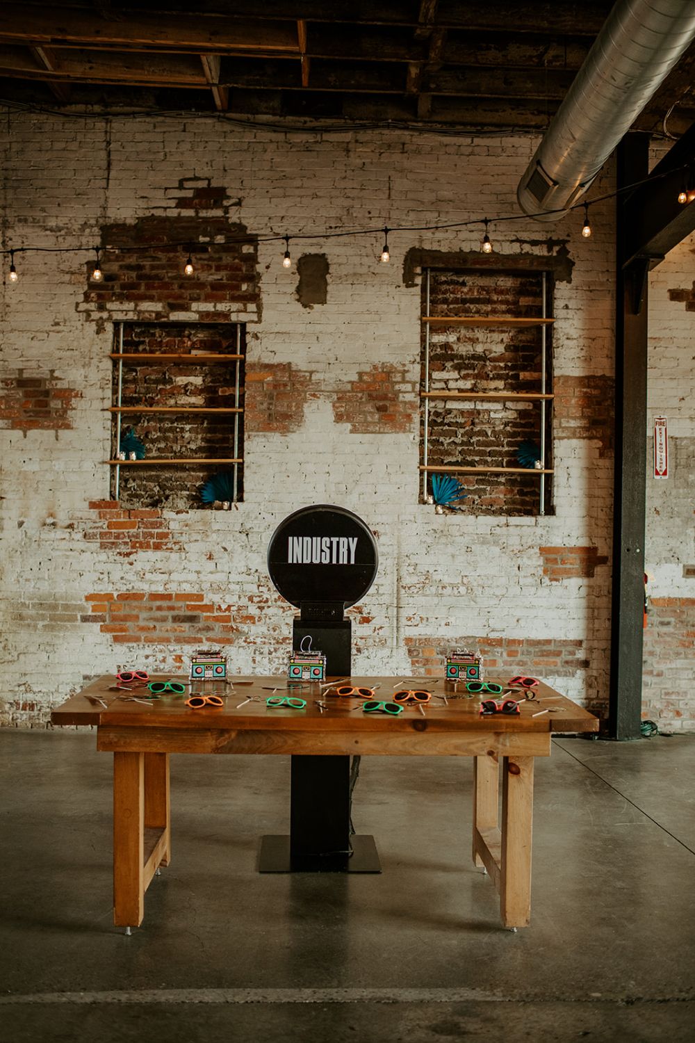 Black standalone photo booth with a table filled with sunglasses to be used as props