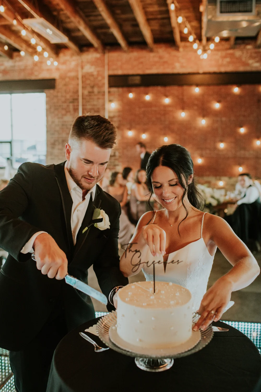 Bride and groom cutting a single-tier wedding cake at INDUSTRY