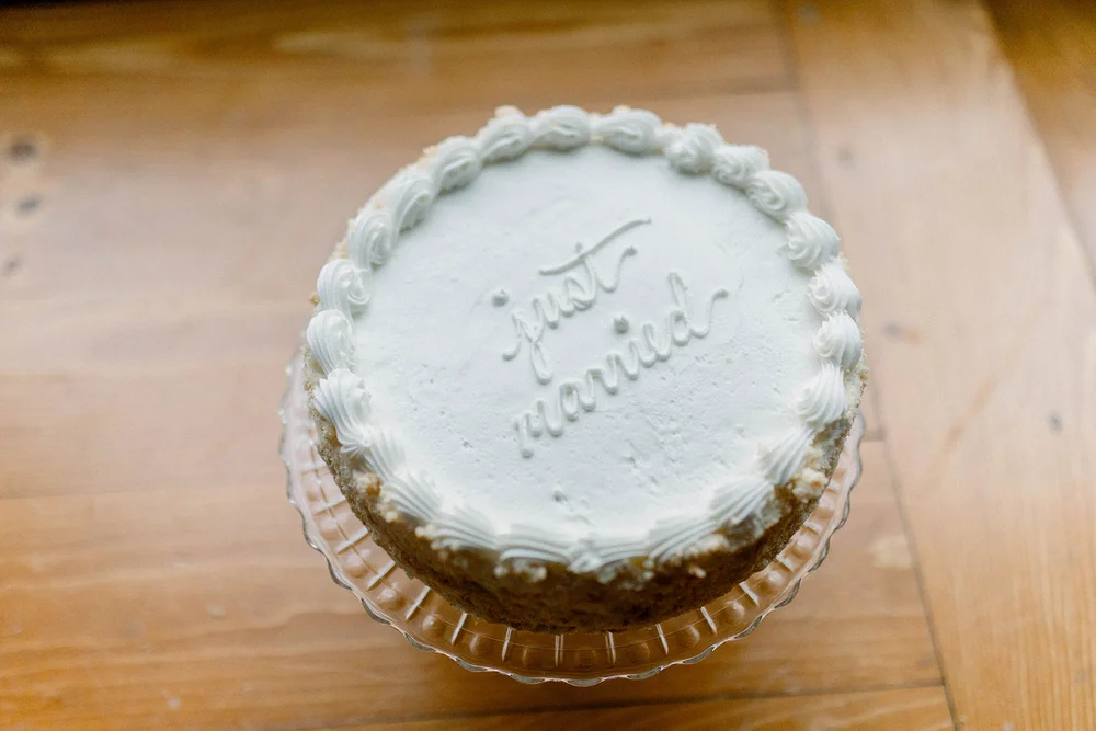 Round white wedding cake with “Just Married” topper displayed at an Indinapolis reception.