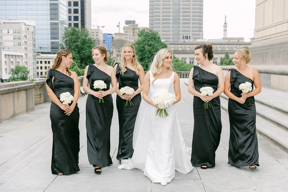 Bride with bridesmaids in black attire at INDUSTRY Indianapolis wedding.