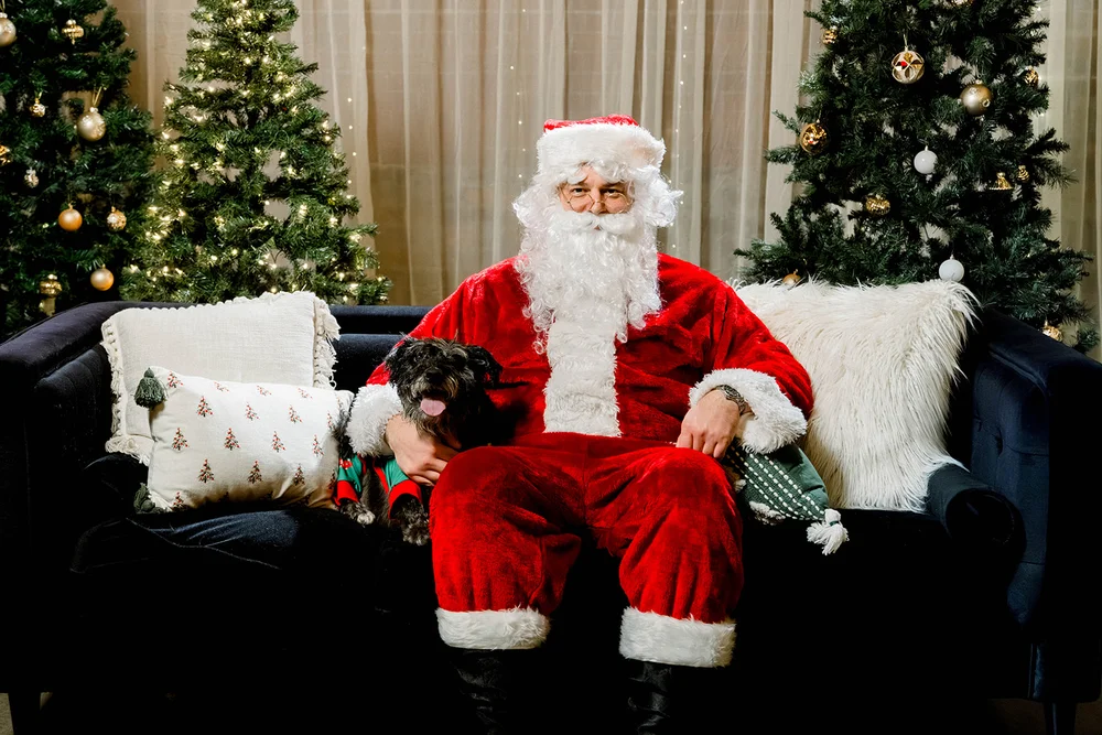Santa posing with a dog at a holiday event at INDUSTRY, Indianapolis event venue